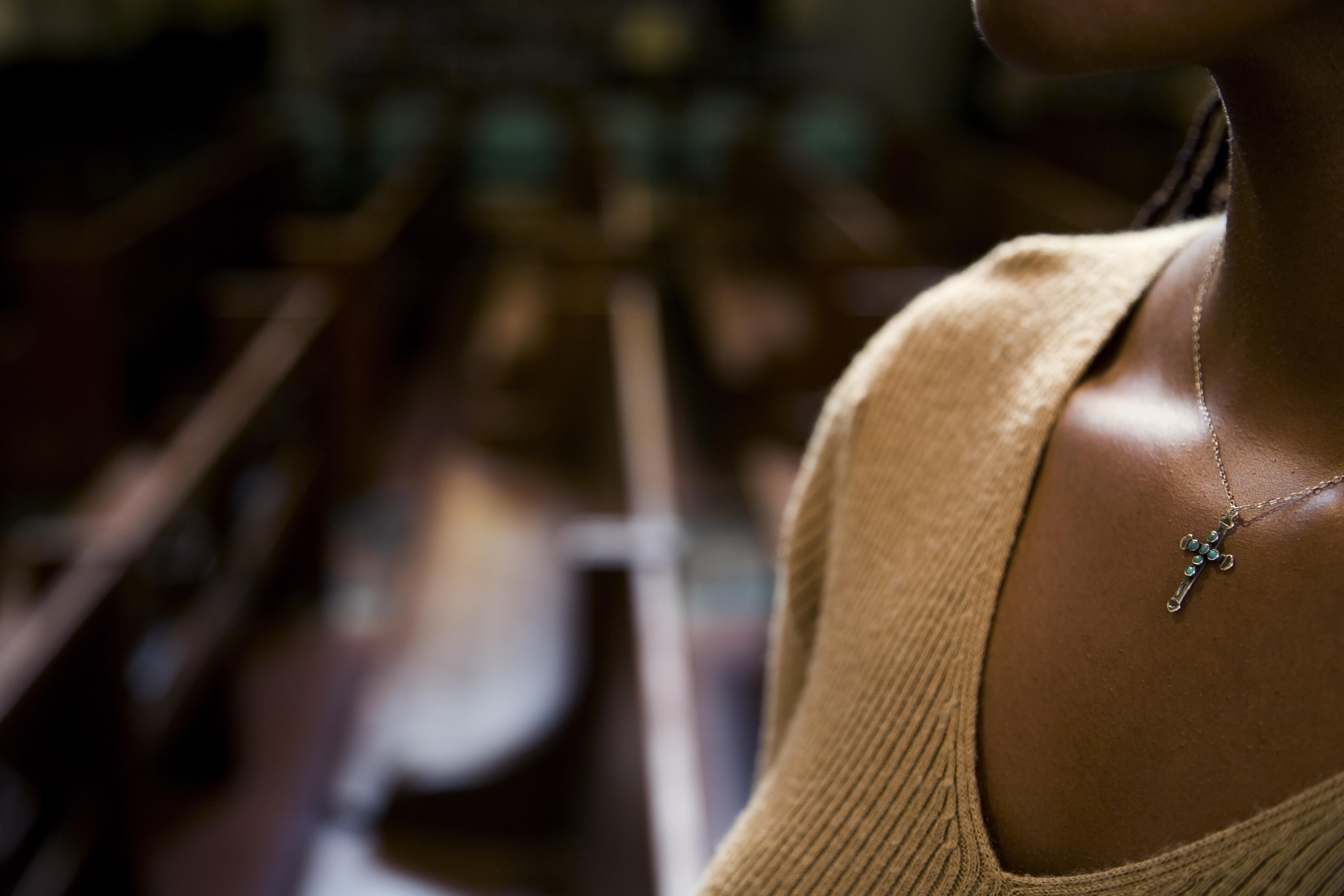 African woman wearing cross necklace in church