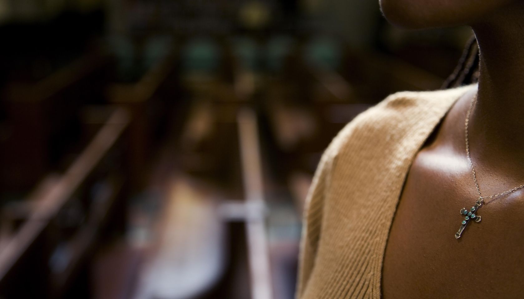 African woman wearing cross necklace in church