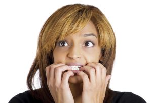 Closeup portrait of young unhappy woman biting her nails and looking to side with a craving for something or anxious worried isolated on white background. Negative emotion facial expression feelings