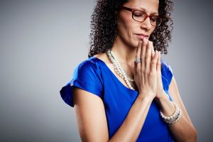 Studio portrait of mature woman praying