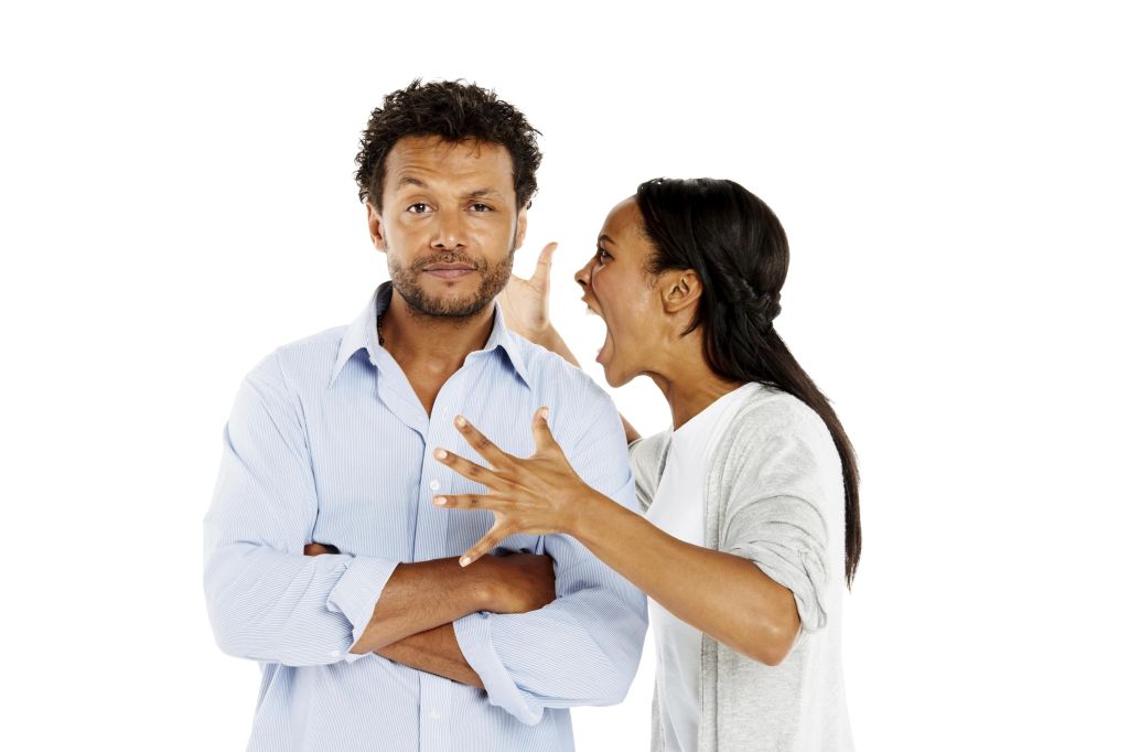 Portrait of young woman shouting at her boyfriend against white background