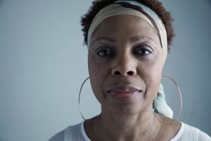Close up portrait serious African American mature woman wearing headscarf and large hoop earrings