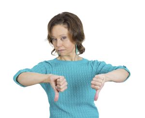 Closeup portrait, unhappy business woman, wife, giving thumbs down sign gesture looking with negative expression and disapproval, isolated white background. Human emotion facial expression, feeling