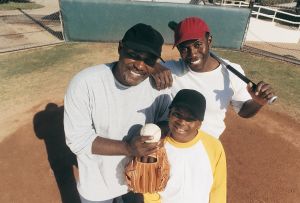 Portrait of a Father Standing With His Two Sons on a Baseball Field