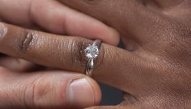 Close up of man putting engagement ring on girlfriend