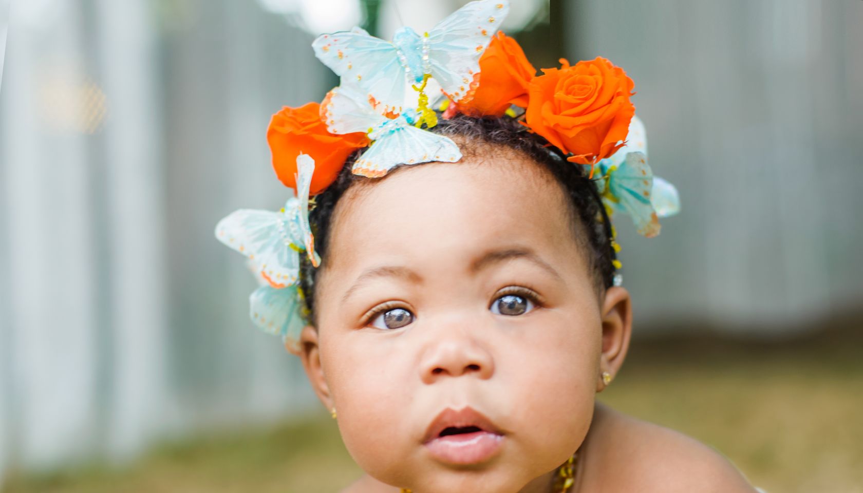 Portrait of baby girl wearing butterflies and flowers in her hair