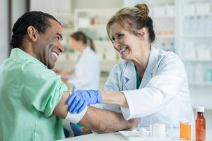 Pharmacist bandages customer's arm after flu shot