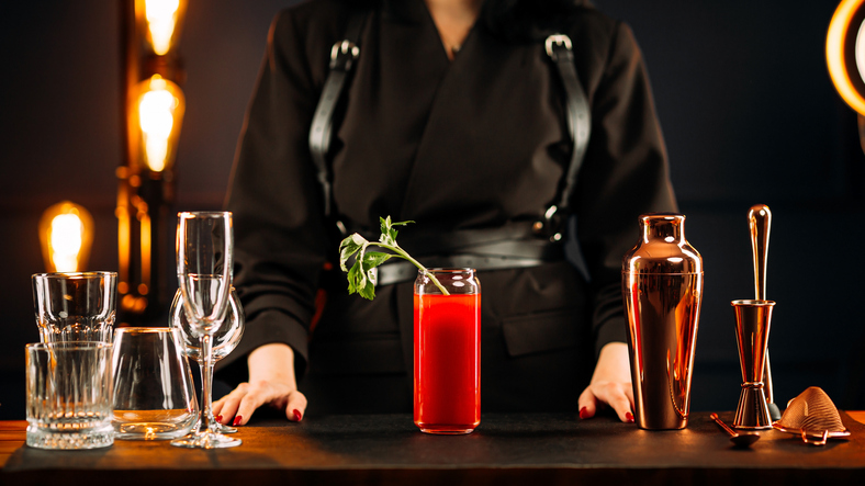 Woman standing behind bar desk with bloody mary