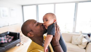 Black Father Holding & Kissing His Baby
