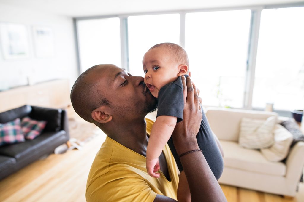 Black Father Holding & Kissing His Baby