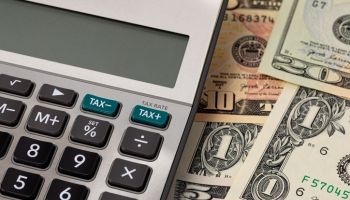 Tax calculator with cash money. Income, sales and property taxes concept.