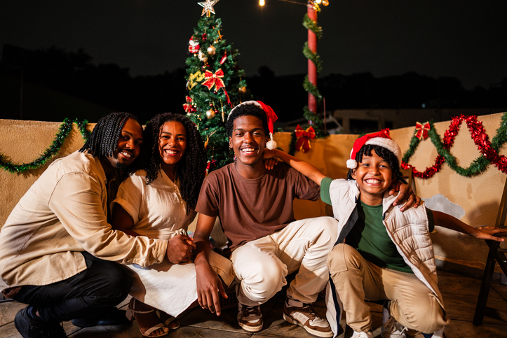 Portrait of a family embracing during christmas night on house rooftop